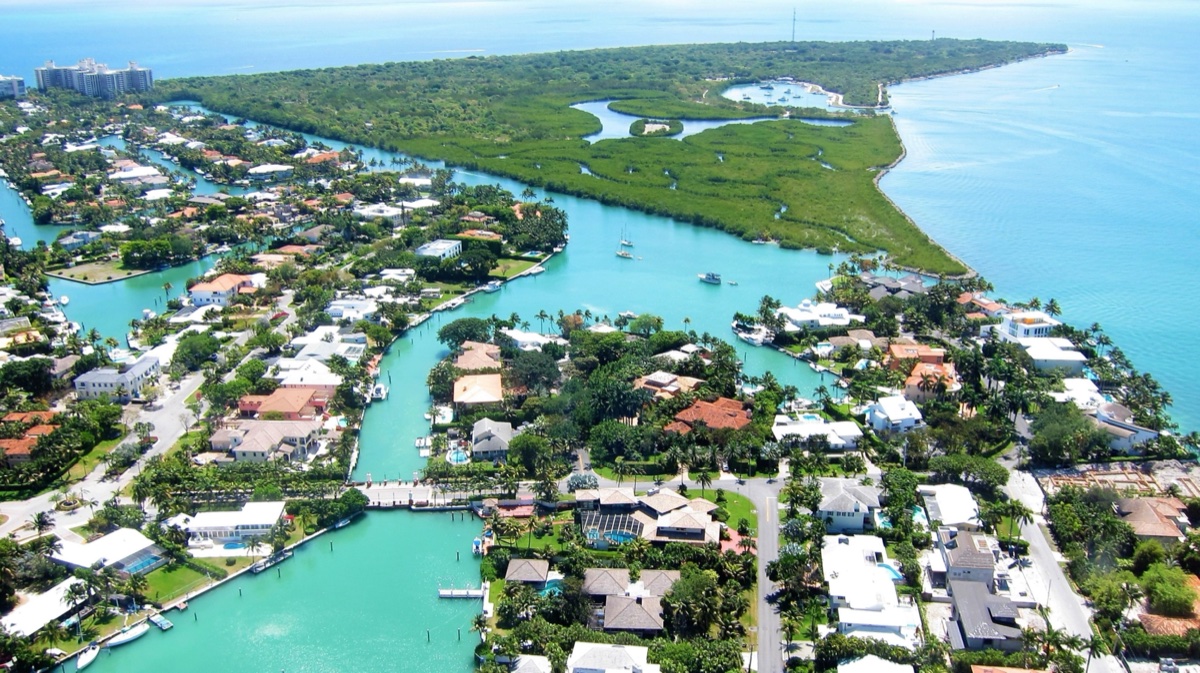 Aerial view of waterfront Key Biscayne homes along a canal with mangrove preserve adjacent